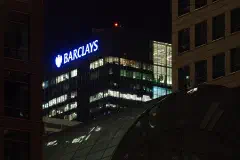 The Barclays building across the City Canal at night.
