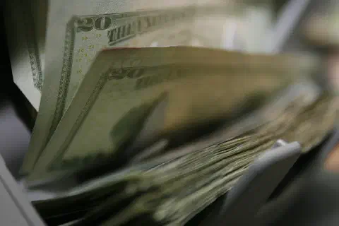 Twenty-dollar bills are counted and packaged for future missions at the Camp Taqaddum Disbursing office June 29, 2006