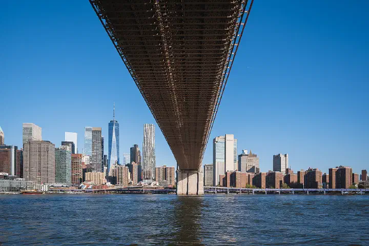The Lower Manhattan skyline seen from beneath the deck of the Brooklyn Bridge, New York City, USA