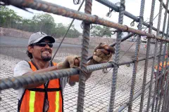A worker assembling rebar at a construction site