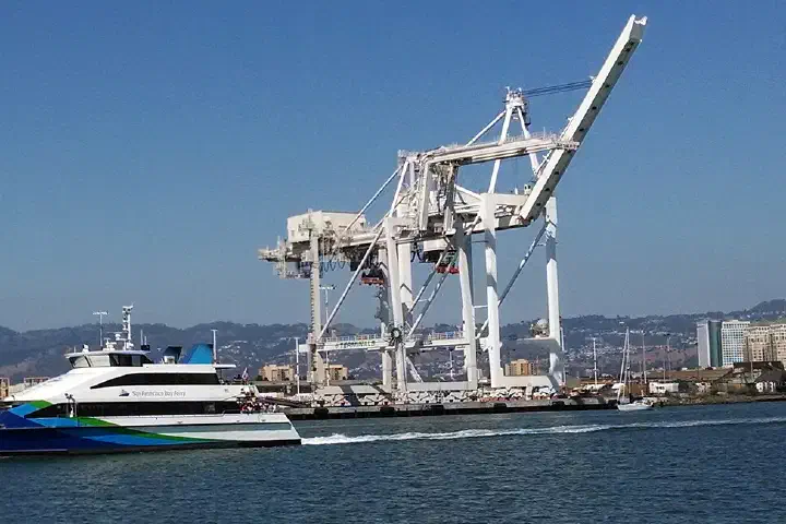 The Scorpio passes port cranes in Oakland Estuary in September 2014