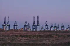 Container cranes at the MSC PSA European Terminal in the Port of Antwerp at dusk.