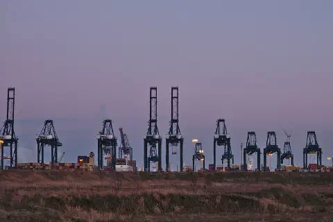 Container cranes at the MPET- MSC PSA European Terminal in Port of Antwerp (Kieldrecht, Belgium) during the sunset civil twilight