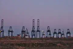 Container cranes at the MSC PSA European Terminal in the Port of Antwerp at dusk.
