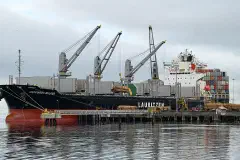The Lauritzen bulk carrier Happiness Bulker loading raw logs at the dock in Port Angeles Harbor, Washington.